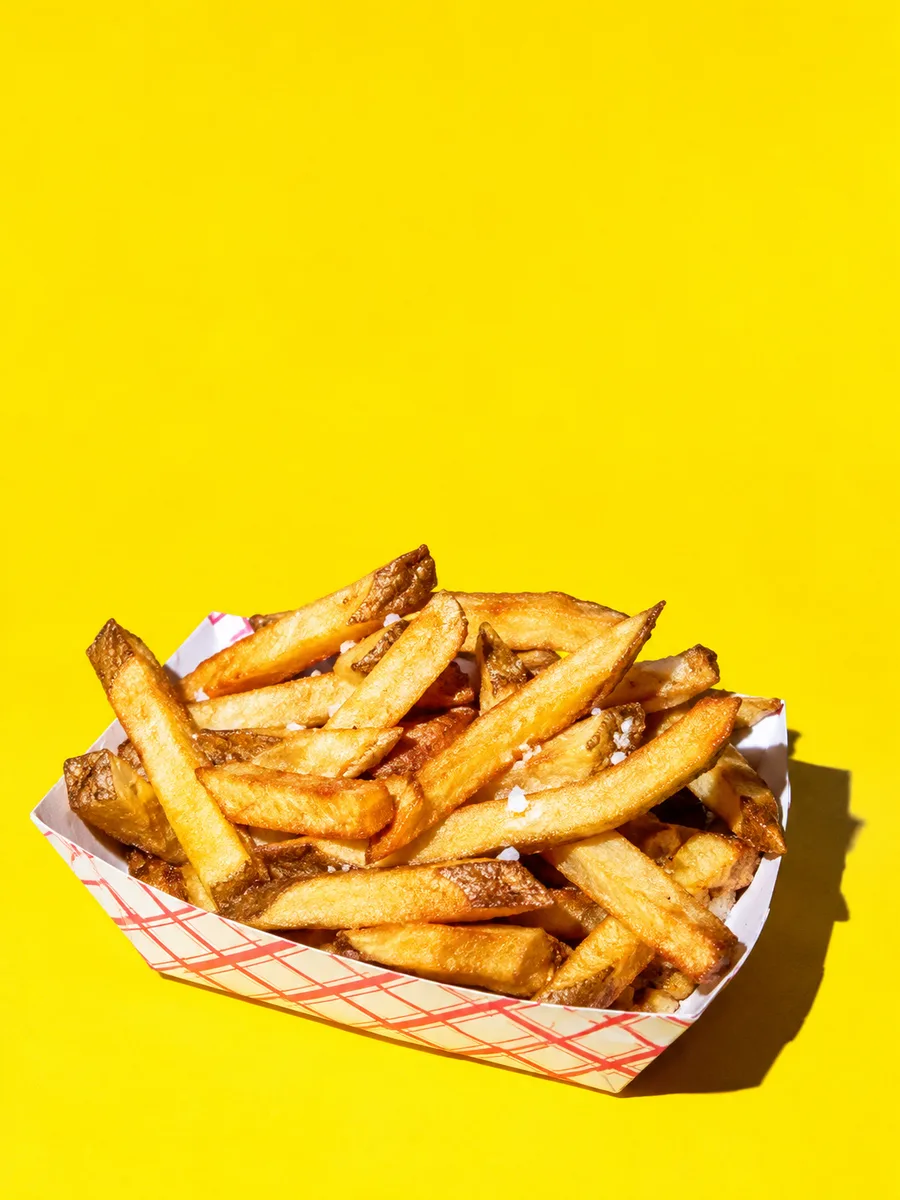 Barquette de frites sur fond jaune