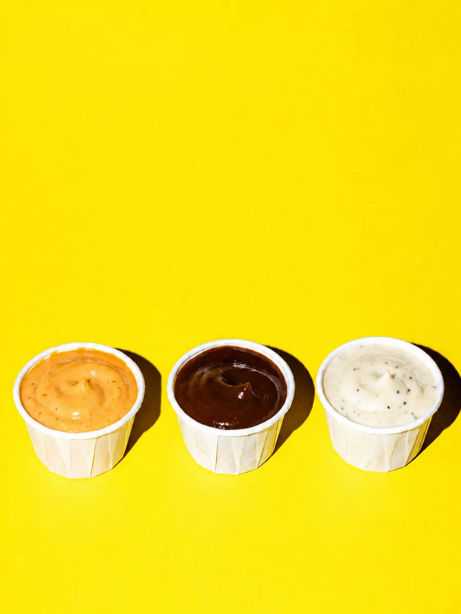 Trois pots de sauce sur fond jaune