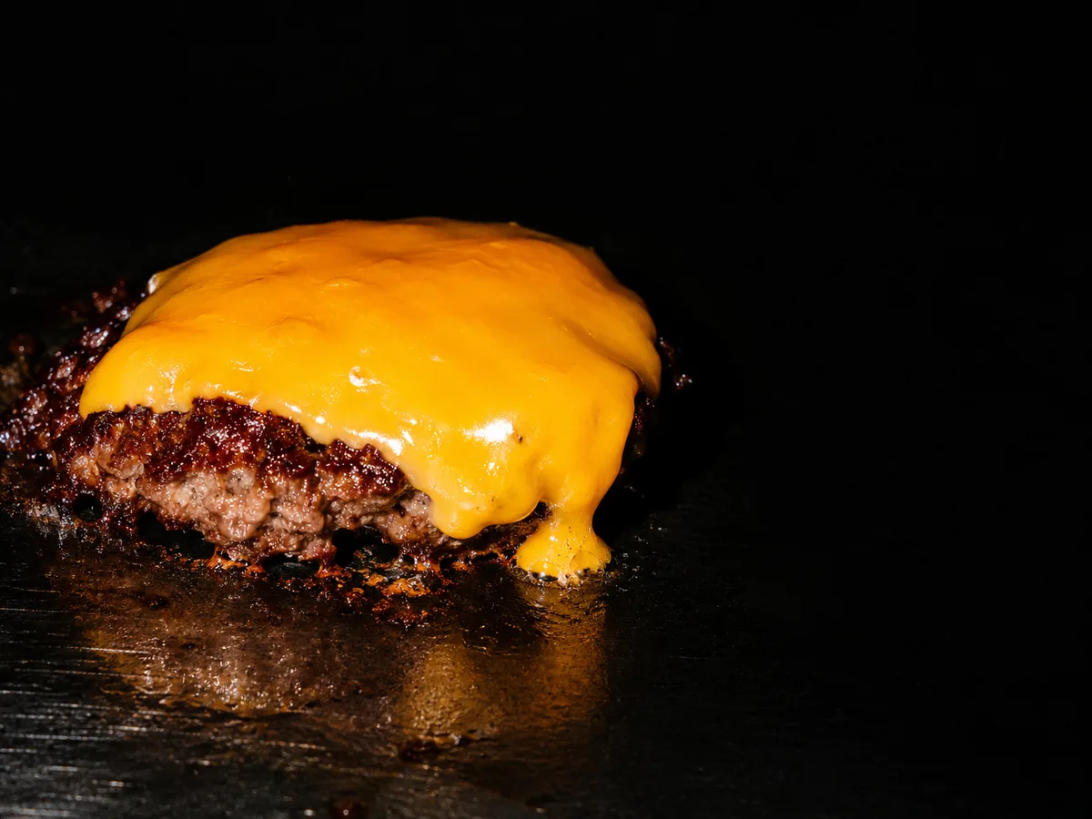 Cheddar qui fond sur un steak, fond noir